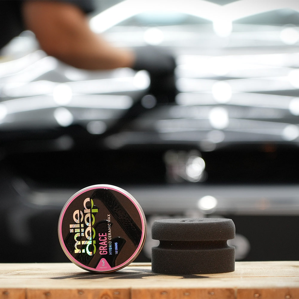 connect car wax application puck next to tin of Grace car wax